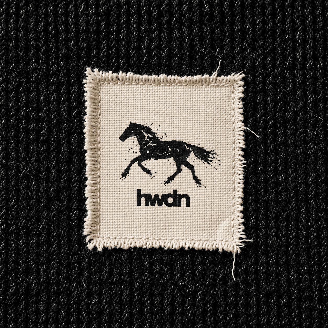 stitched hwdn label on black fabric